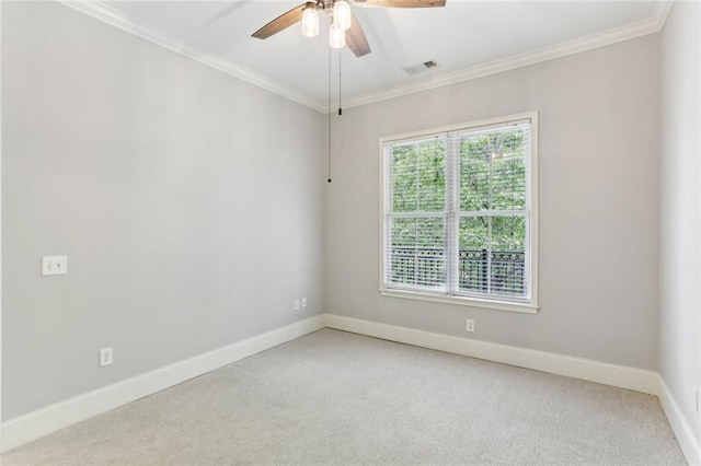 empty room with ornamental molding, light carpet, baseboards, and a ceiling fan