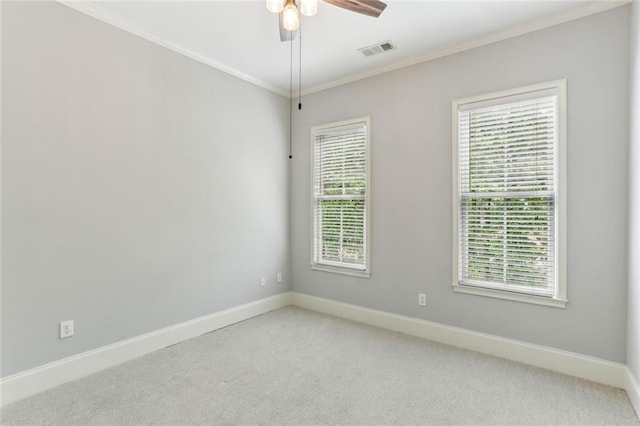 unfurnished room featuring light colored carpet, healthy amount of natural light, ceiling fan, and crown molding