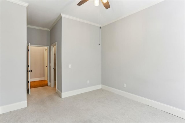 empty room featuring light carpet, ceiling fan, ornamental molding, and baseboards