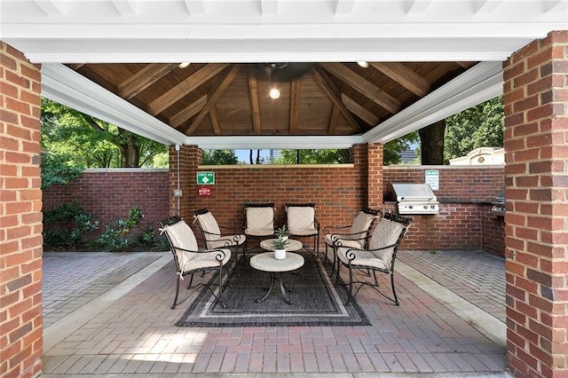 view of patio / terrace featuring a gazebo, an outdoor kitchen, grilling area, and fence