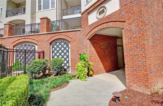 doorway to property with stucco siding and brick siding