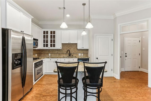 kitchen featuring appliances with stainless steel finishes, crown molding, white cabinets, light wood-type flooring, and glass insert cabinets