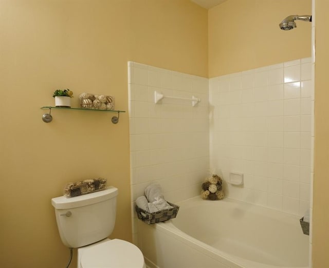 bathroom featuring tiled shower / bath combo and toilet