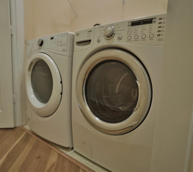 laundry area featuring washer and clothes dryer and hardwood / wood-style floors