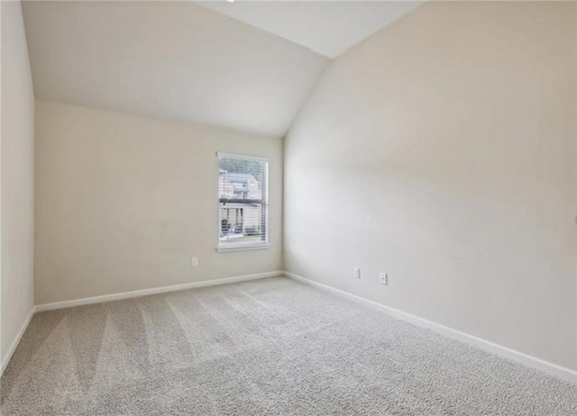 empty room with lofted ceiling and carpet flooring