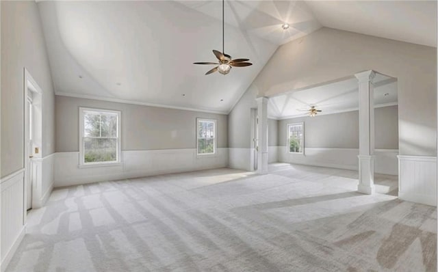 interior space featuring decorative columns, lofted ceiling, and light colored carpet