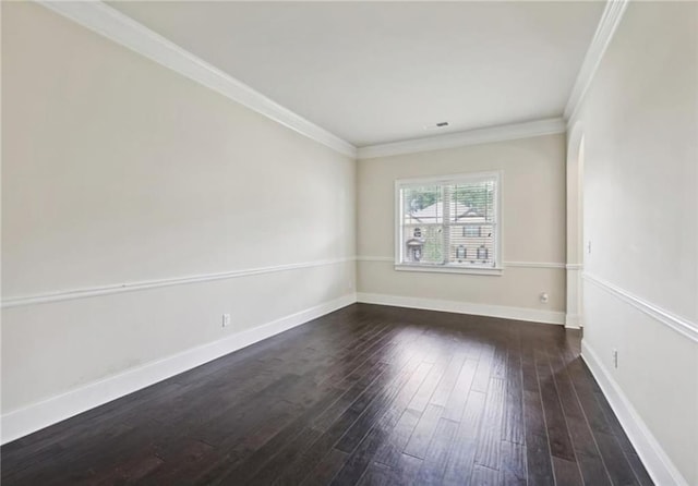 empty room with ornamental molding and dark wood-type flooring