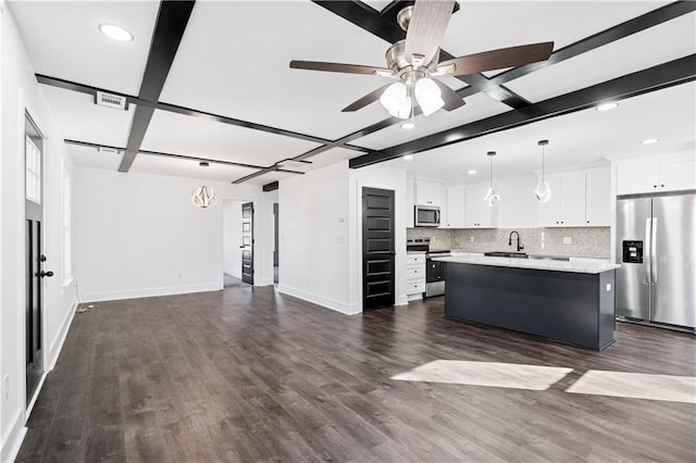 kitchen featuring hanging light fixtures, backsplash, stainless steel appliances, white cabinets, and a kitchen island