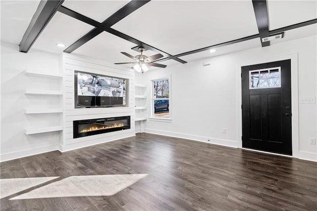 unfurnished living room with a large fireplace, plenty of natural light, dark hardwood / wood-style floors, and built in features