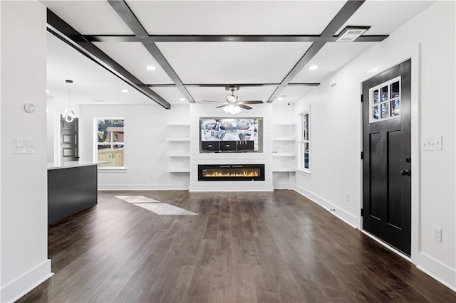 unfurnished living room featuring ceiling fan, dark hardwood / wood-style floors, coffered ceiling, a large fireplace, and built in shelves