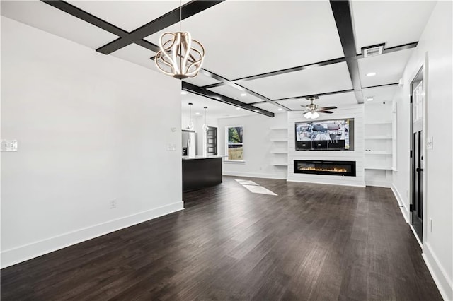 unfurnished living room featuring coffered ceiling, a fireplace, built in shelves, dark hardwood / wood-style flooring, and ceiling fan with notable chandelier