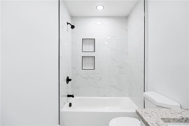 full bathroom featuring tiled shower / bath combo, vanity, and toilet