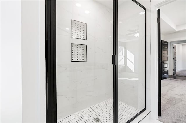 interior space featuring a shower with shower door and ceiling fan