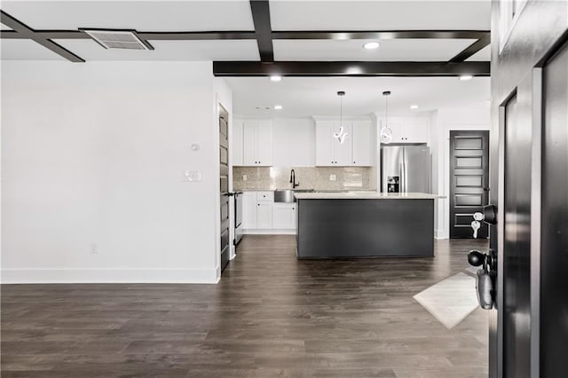 kitchen with pendant lighting, backsplash, white cabinets, a kitchen island, and stainless steel fridge with ice dispenser