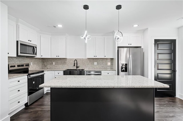 kitchen featuring appliances with stainless steel finishes, a center island, sink, and white cabinets