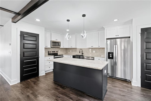 kitchen featuring white cabinetry, hanging light fixtures, stainless steel appliances, a center island, and light stone counters