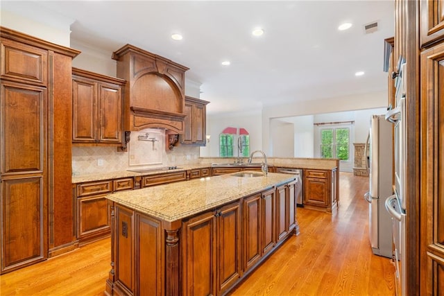 kitchen with stainless steel appliances, a peninsula, a sink, visible vents, and tasteful backsplash