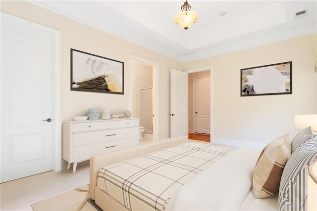 bedroom featuring a raised ceiling, light colored carpet, visible vents, connected bathroom, and baseboards