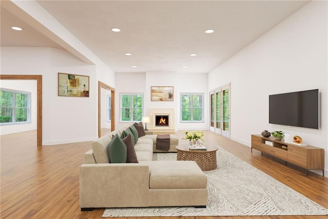 living area with a warm lit fireplace, baseboards, wood finished floors, and recessed lighting