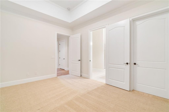 unfurnished bedroom featuring ornamental molding, light carpet, and baseboards