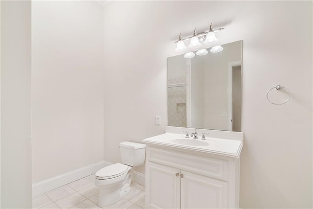 bathroom with toilet, tile patterned floors, baseboards, and vanity