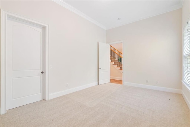 unfurnished room with baseboards, ornamental molding, and carpet flooring