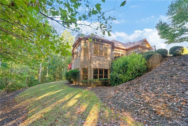 view of side of property with a yard and brick siding