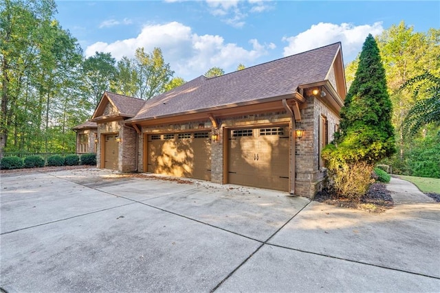 view of front of home with a shingled roof, concrete driveway, brick siding, and an attached garage