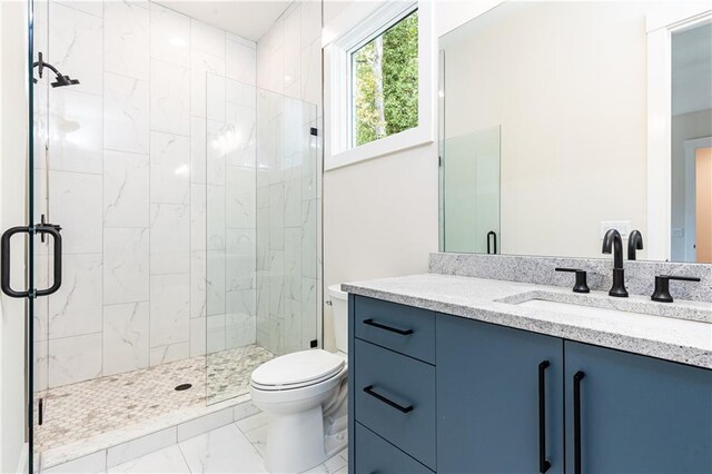 bathroom featuring vanity, toilet, and a shower with door