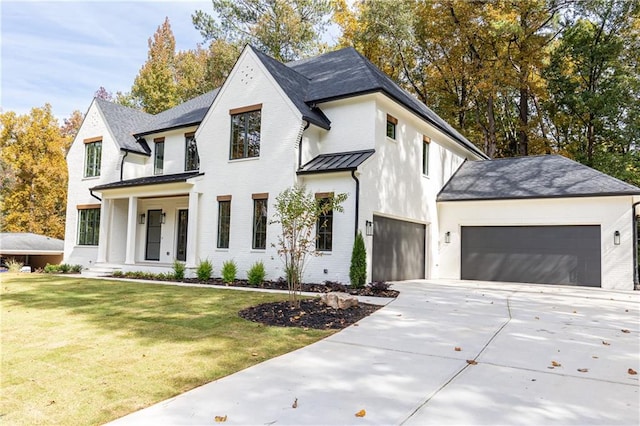 modern inspired farmhouse featuring a garage and a front lawn