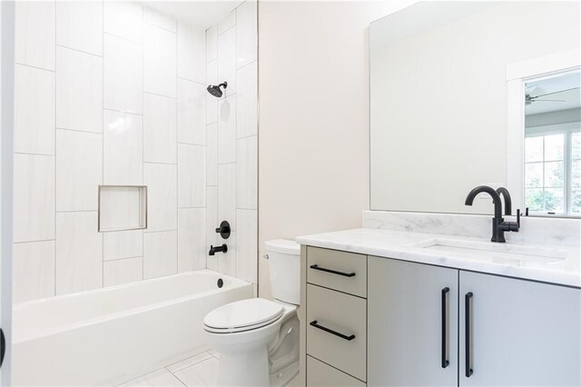 full bathroom featuring toilet, tile patterned flooring, vanity, tiled shower / bath combo, and ceiling fan