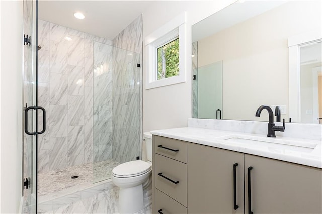 bathroom featuring a shower with shower door, toilet, and vanity