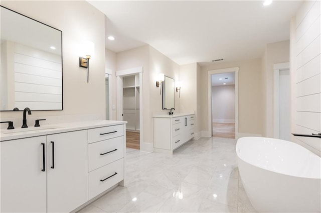 bathroom with a tub to relax in and vanity