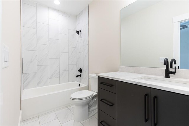 full bathroom featuring tiled shower / bath, vanity, and toilet