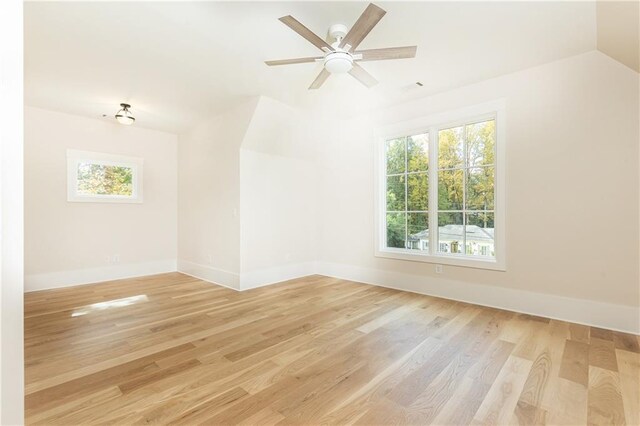 empty room with light wood-type flooring, lofted ceiling, and ceiling fan