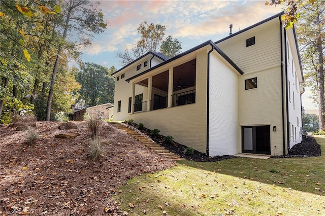 view of home's exterior featuring a lawn and a balcony