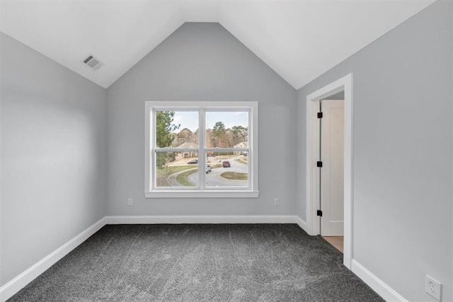 unfurnished room featuring visible vents, carpet floors, baseboards, and vaulted ceiling