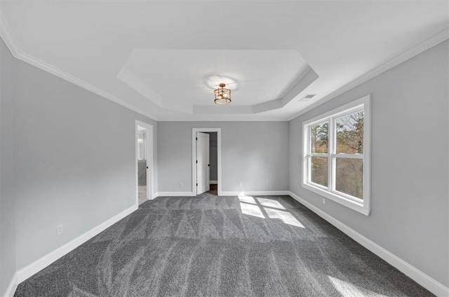 unfurnished room featuring a tray ceiling, baseboards, dark colored carpet, and ornamental molding