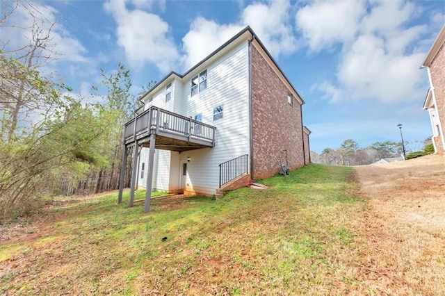 back of property with a yard and a wooden deck