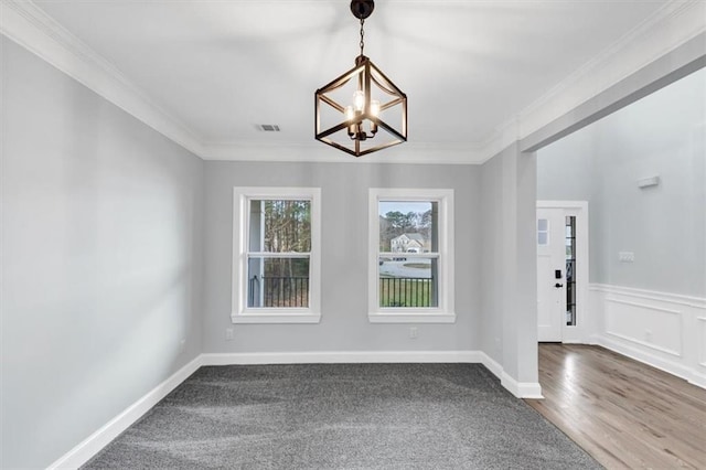 spare room with dark wood-style floors, baseboards, visible vents, crown molding, and a chandelier