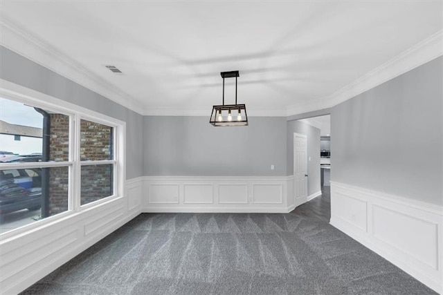 unfurnished dining area featuring visible vents, a wainscoted wall, dark carpet, and ornamental molding