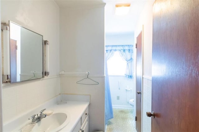 bathroom with toilet, tile walls, and vanity
