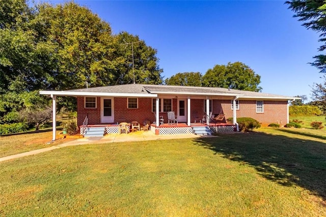 view of front of home with covered porch, brick siding, and a front lawn