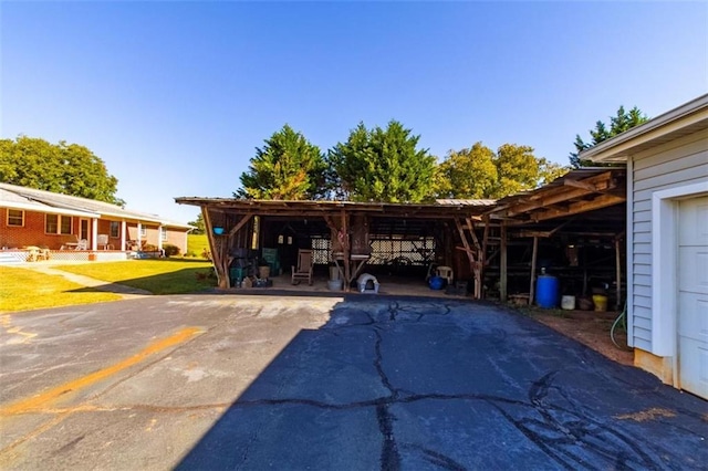 view of vehicle parking featuring driveway and a carport
