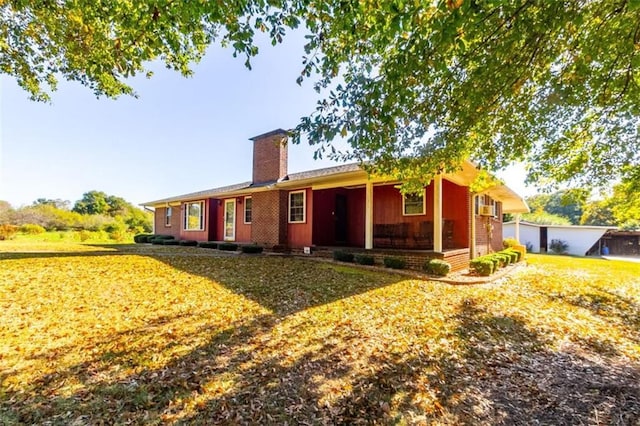 exterior space featuring covered porch, a lawn, and a chimney