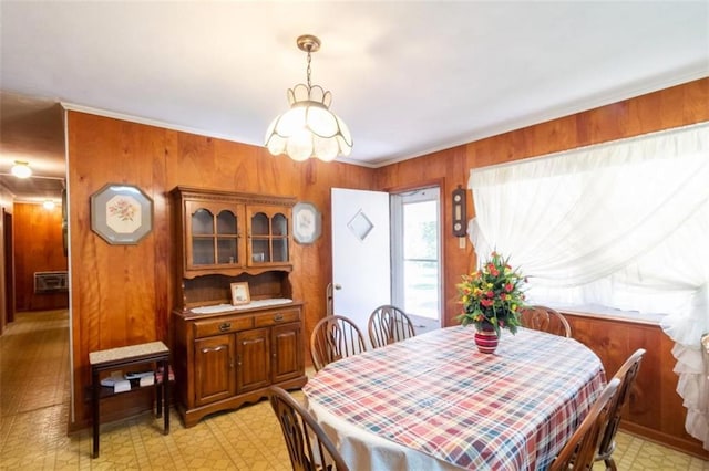dining room featuring wooden walls, a wall unit AC, and light floors