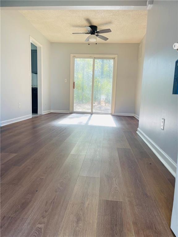 unfurnished room with dark wood-type flooring, a textured ceiling, and ceiling fan