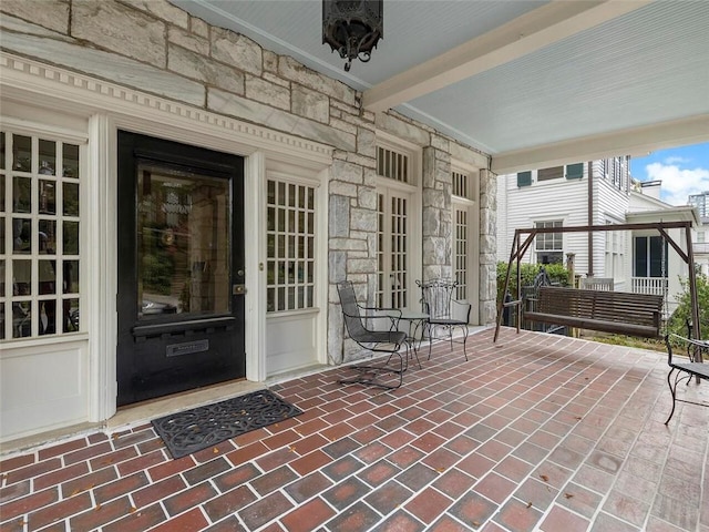 property entrance with stone siding and covered porch