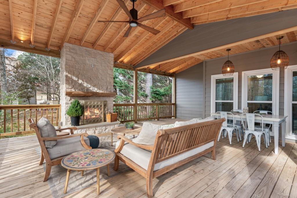 deck featuring ceiling fan and an outdoor living space with a fireplace