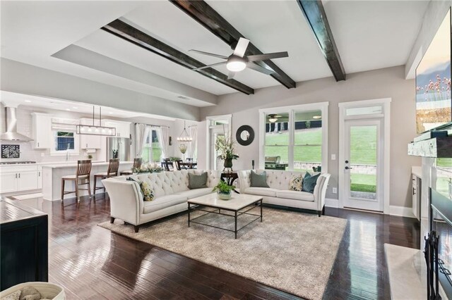 living room with dark wood-type flooring, ceiling fan, and plenty of natural light